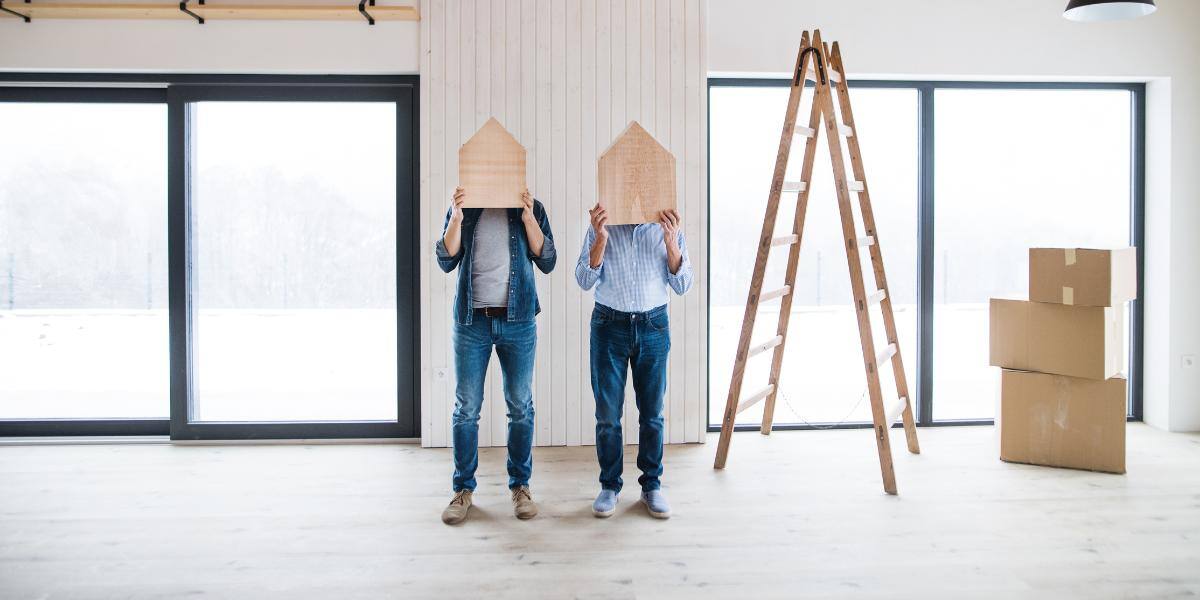 Contractors holding wooden houses on their heads